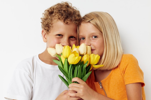 Amizade de férias de crianças pré-escolares fofas com um presente Estilo de vida de flores amarelas inalterado