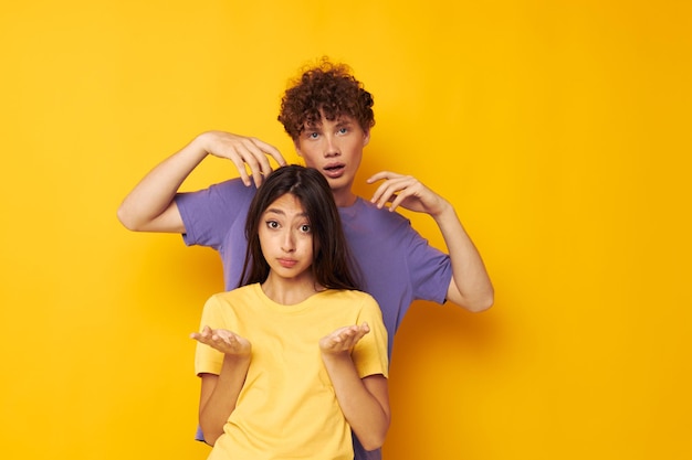 Amizade de jovem casal fofo posando fundo amarelo de estúdio divertido inalterado