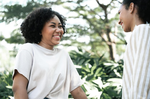 Amizade duas jovens lindas garotas sorridentes e diversão conversando no jardim