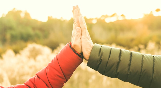 Foto amizade e conceito de relacionamento com as mãos apertadas homem e mulher ao ar livre com a natureza em fundo pessoas irreconhecíveis equipe e ajuda casal dando cinco amor e amigos atividade de lazer