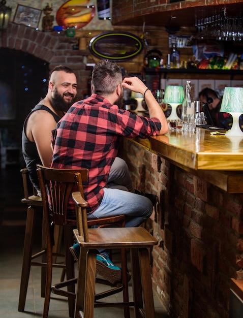 Amizade e lazer Amigos relaxando no bar Pedir bebidas no balcão do bar Homem barbudo brutal hipster passa lazer com amigo no balcão do bar Homens relaxando no bar Sexta-feira relaxamento no bar