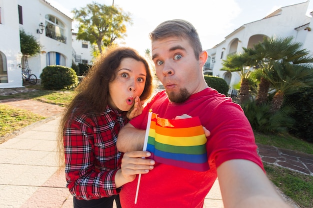 Amizade gay e lésbica segurando a bandeira do arco-íris