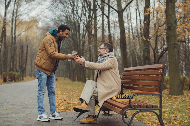 Amizade multicultural de pessoas de diferentes idades Um encontro de dois amigos para um jogo de xadrez no parque