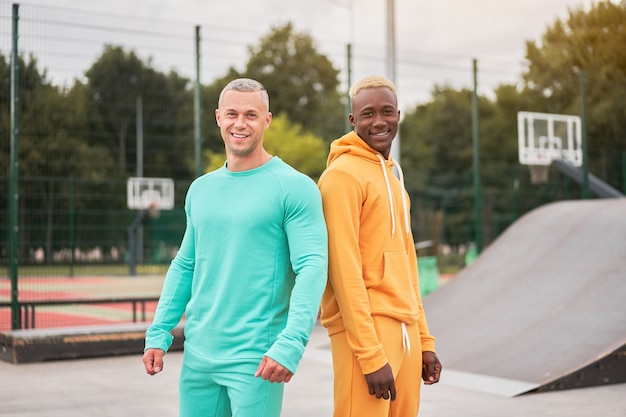 Amizade multiétnica. Amigos negros afro-americanos e caucasianos passando um tempo juntos na pista de skate