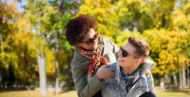 Foto amizade, temporada, conceito internacional e de pessoas - casal adolescente feliz em tons se divertindo sobre o fundo do parque outono