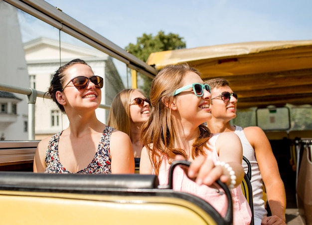 amizade, viagens, férias, verão e conceito de pessoas - grupo de amigos sorridentes viajando de ônibus de turismo