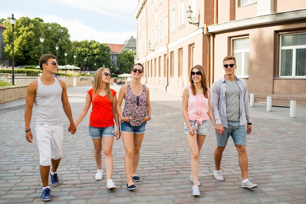 amizade, viagens, turismo, férias de verão e conceito de pessoas - grupo de adolescentes sorridentes andando na cidade
