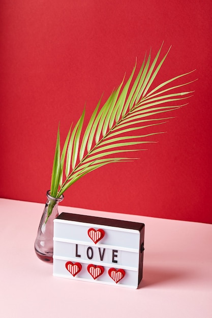 Amo a mensagem lightbox com corações vermelhos e folha de palmeira