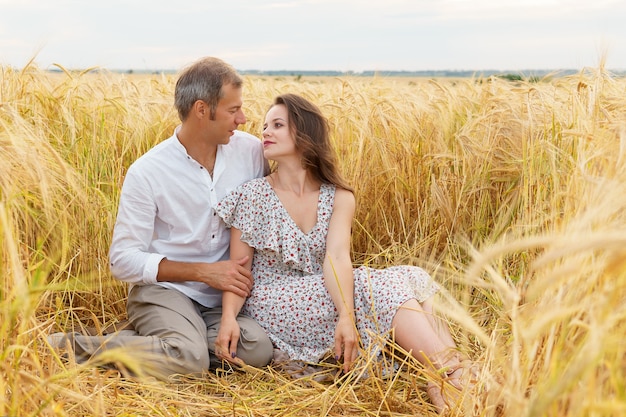 Amo o casal abraços juntos em um campo de trigo. Homem e mulher no prado do verão. Data Romantica