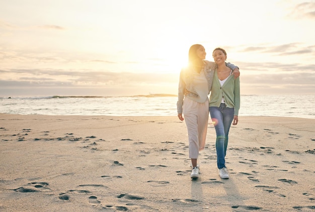 Amo la playa y la pareja de lesbianas al atardecer caminando juntos en la arena, la aventura de vacaciones al atardecer o un abrazo en una cita Las mujeres Lgbt se unen y se relajan en vacaciones en el océano con orgullo romántico y viajes felices por la naturaleza