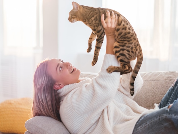 Amo la relación entre humanos y animales. amigo peludo. tiempo de abrazos. niña sosteniendo a su gatito en el aire.