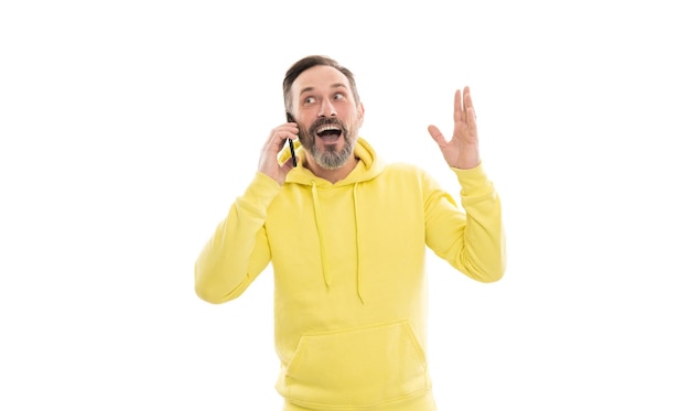 Amocional apuesto hombre maduro con capucha hablando por teléfono aislado en comunicación blanca