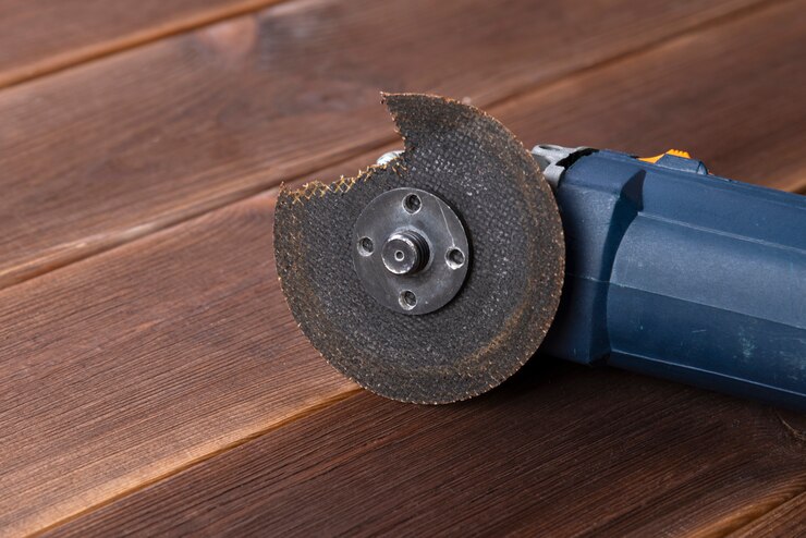 Foto una amoladora con una cuchilla rota en una mesa de madera. el peligro de usar herramientas eléctricas