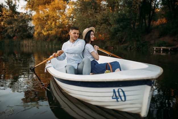 Amor abrazos de pareja en un barco en el lago tranquilo