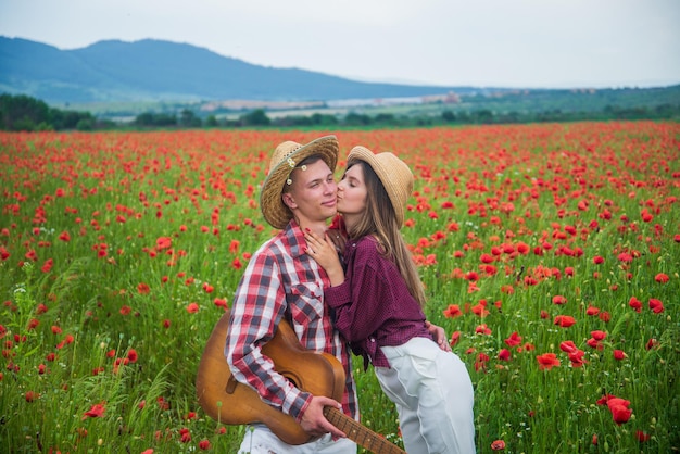 Amor apasionado vacaciones de verano familia feliz música country primavera naturaleza belleza romance relación romántica pareja enamorada de guitarra hombre y mujer en campo de flor de amapola