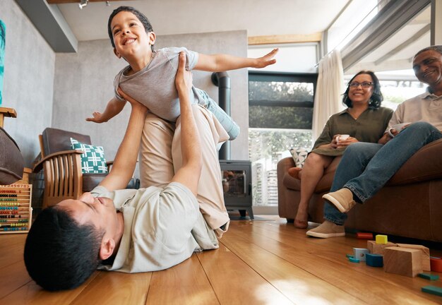 Foto amor en avión y niño con padre en el suelo para jugar y vincularse en casa con los abuelos fantasía voladora y niño emocionado con sus padres en la sala de estar para pasar un rato divertido en familia en una casa