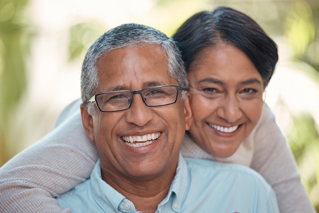 Amor casal de aposentados e abraço de retrato com sorriso feliz e abraço romântico no jardim Idosos casados e pessoas latinas em compromisso de relacionamento junto com cuidado e apoio