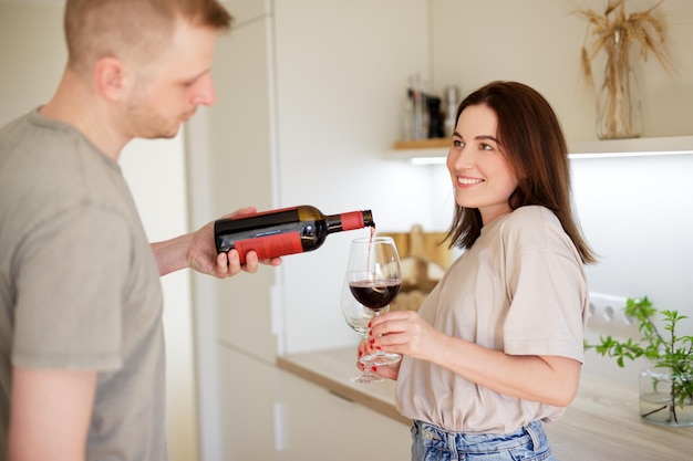 amor, citas, y, romance, concepto, lindo, pareja, enamorado, vertido, vino rojo, en, copas, en, brillante, cocina