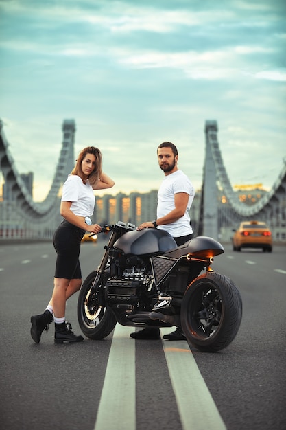 Foto amor y concepto romántico hermosa pareja en motocicleta se encuentra uno frente al otro en medio de la carretera en el puente, en doble sólido.