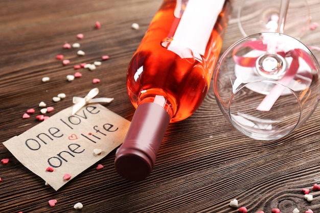 Un amor, un concepto de vida - botella de vino y copas con corazones alrededor, de cerca