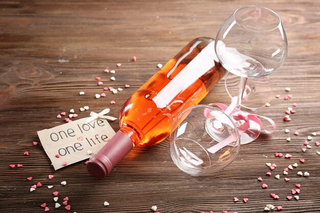 Un amor, un concepto de vida - botella de vino y copas con corazones alrededor, de cerca