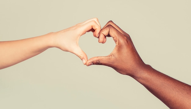 Foto amor de caridade e diversidade de mãos femininas e masculinas de diferentes cores de pele fazendo formato de coração