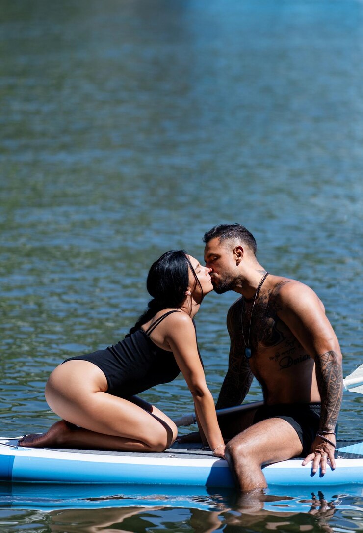 Foto amor de verão casal sexy sentar-se na prancha de remo e beijar mulher sexy e homem abraço e beijo em