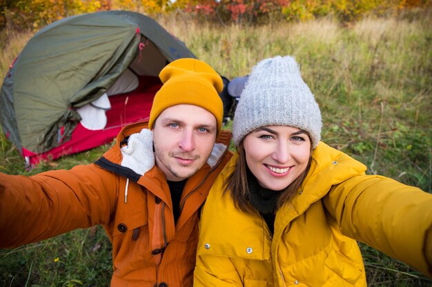 amor de viagem e retrato do conceito de outono de um lindo casal apaixonado tirando fotos de selfie na floresta de outono