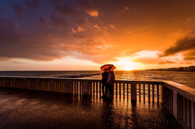 Amor en una espléndida puesta de sol mientras llueve