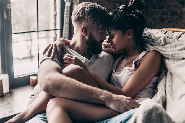 El amor está en el aire. pareja joven sentada cara a cara y manteniendo los ojos cerrados