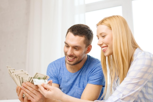 Foto amor, família, finanças, dinheiro e felicidade - casal sorridente com dinheiro em casa