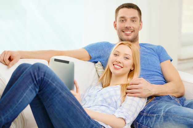 El amor, la familia, la tecnología, Internet y el concepto de felicidad: una pareja feliz sonriente con una tableta en casa