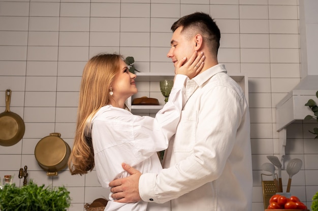 Amor feliz pareja abrazándose con alegría en el interior de la cocina de casa