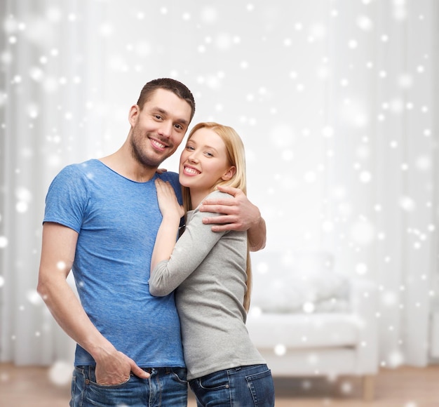 amor, gente y concepto familiar - pareja sonriente abrazándose en casa