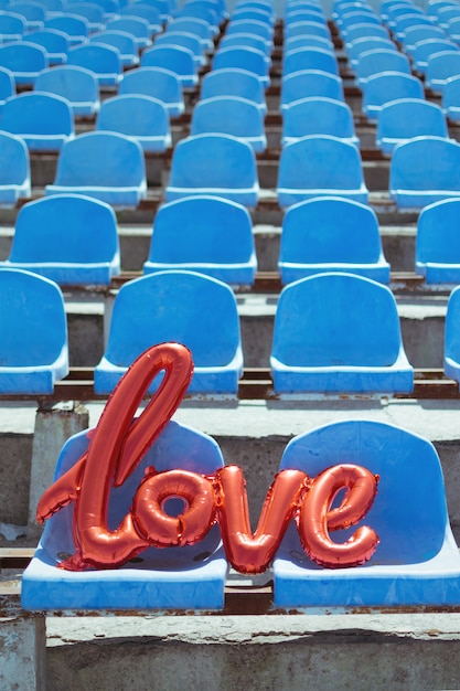 Amor globo de aluminio rojo en los asientos del estadio azul