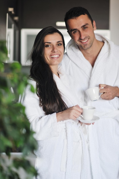 Amor joven pareja tomando una taza de café fresco por la mañana en el apartamento moderno