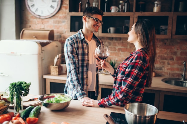 Amor pareja bebiendo vino en la cocina de casa