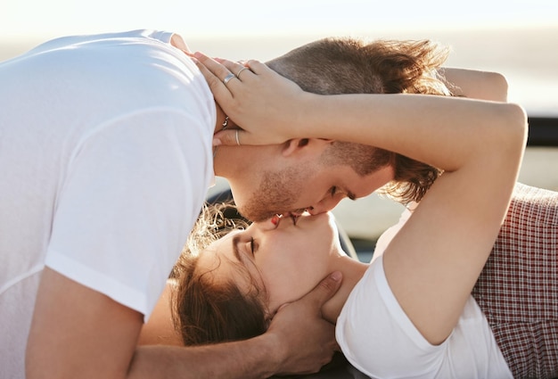 Amor de pareja y beso con un hombre y una mujer en un viaje por carretera para sus vacaciones de luna de miel o viajes Romance besándose y juntos con un hombre y una mujer disfrutando de una cita juntos durante el verano