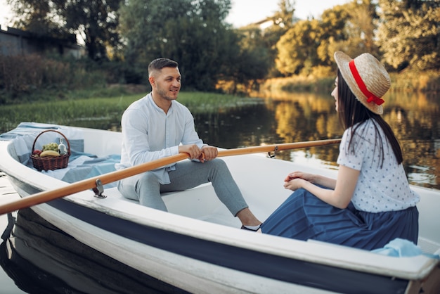 Amor pareja paseando en bote por el lago, encuentro romántico