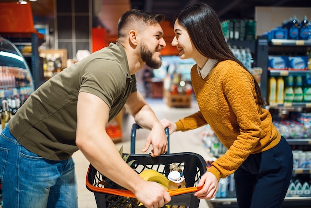 Amor pareja posa en la tienda de comestibles