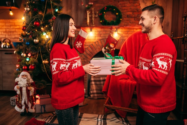 Amor pareja sosteniendo caja de regalo en las manos, Navidad