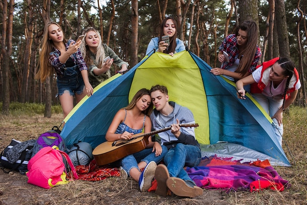 Foto amor pareja tocando la guitarra concepto de paparazzi. equipo turístico. romance musical.