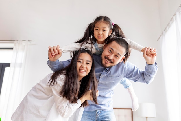 amor parental e cuidado família feliz asiática com filha pequena se alegram em casa