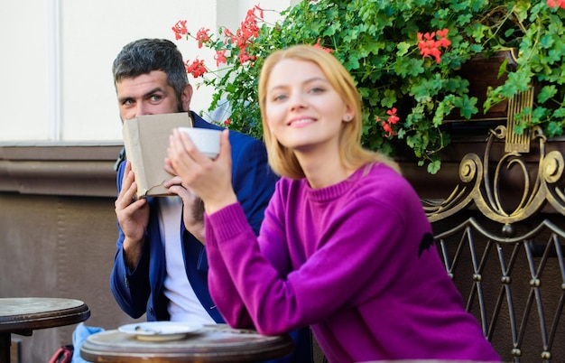 Amor a primera vista mujer y hombre con barba se relajan en el café Brutal hipster barbudo y niña beben café Pareja enamorada en cita romántica Primer encuentro de niña y hombre maduro Café de la mañana