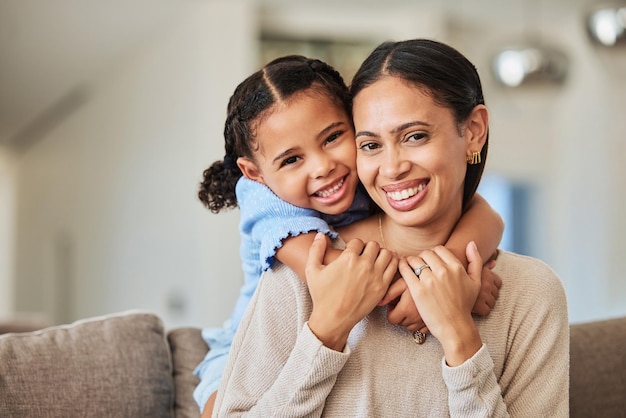 El amor se relaja y la madre y la niña en el sofá con un abrazo para la familia feliz y el estilo de vida juntos Sonríe el apoyo y la confianza con el retrato de la madre y el niño en la sala de estar en casa para el cuidado de los jóvenes y la felicidad