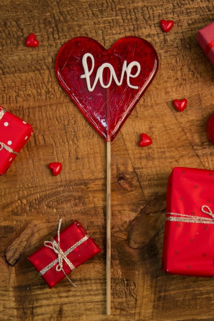 Amor rojo Lollipop, presenta y corazones de cristal en miniatura en la mesa de madera. Decoración de San Valentín