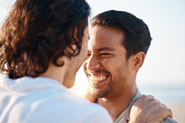 El amor sonríe y la pareja gay en la playa se abraza y se ríe en las vacaciones de verano juntos en Tailandia. El sol del mar y los hombres lgbt se relajan felices abrazados en la naturaleza en vacaciones divertidas y el cuidado del orgullo y el romance de la isla.