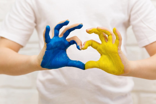 Foto amor ucrania concepto manos en forma de corazón pintadas en ucrania bandera color amarillo y azul selecrive focus día de la independencia de ucrania bandera día de la constitución educación escuela arte pintura concepto