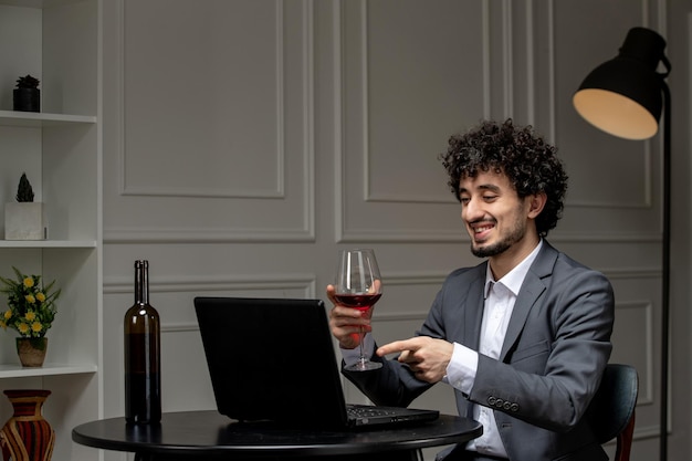 Amor virtual bonitão bonito de terno com vinho em um encontro de computador à distância sorrindo adorável