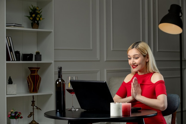 Amor virtual linda garota loira de vestido vermelho no encontro à distância com vinho juntando as mãos